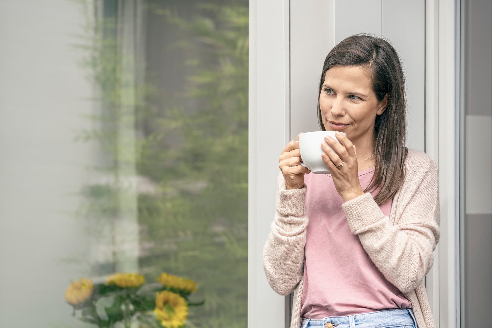 Entspannte Kundin hält Kaffeetasse – Solaranlage mit SWK Photovoltaik Kredit 