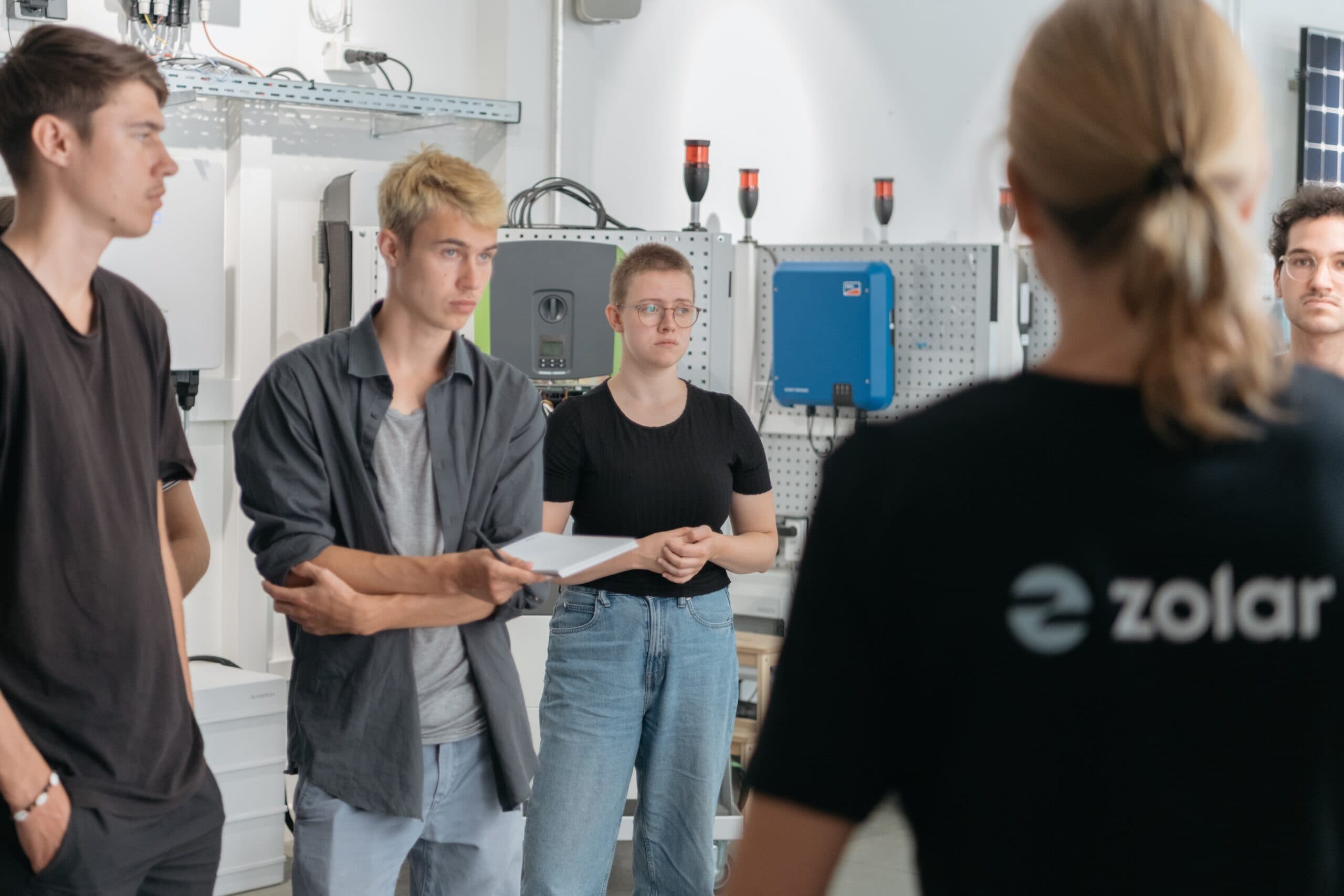 Mehrere Junge Menschen vor Photovoltaik Komponenten – Das Solarcamp von zolar