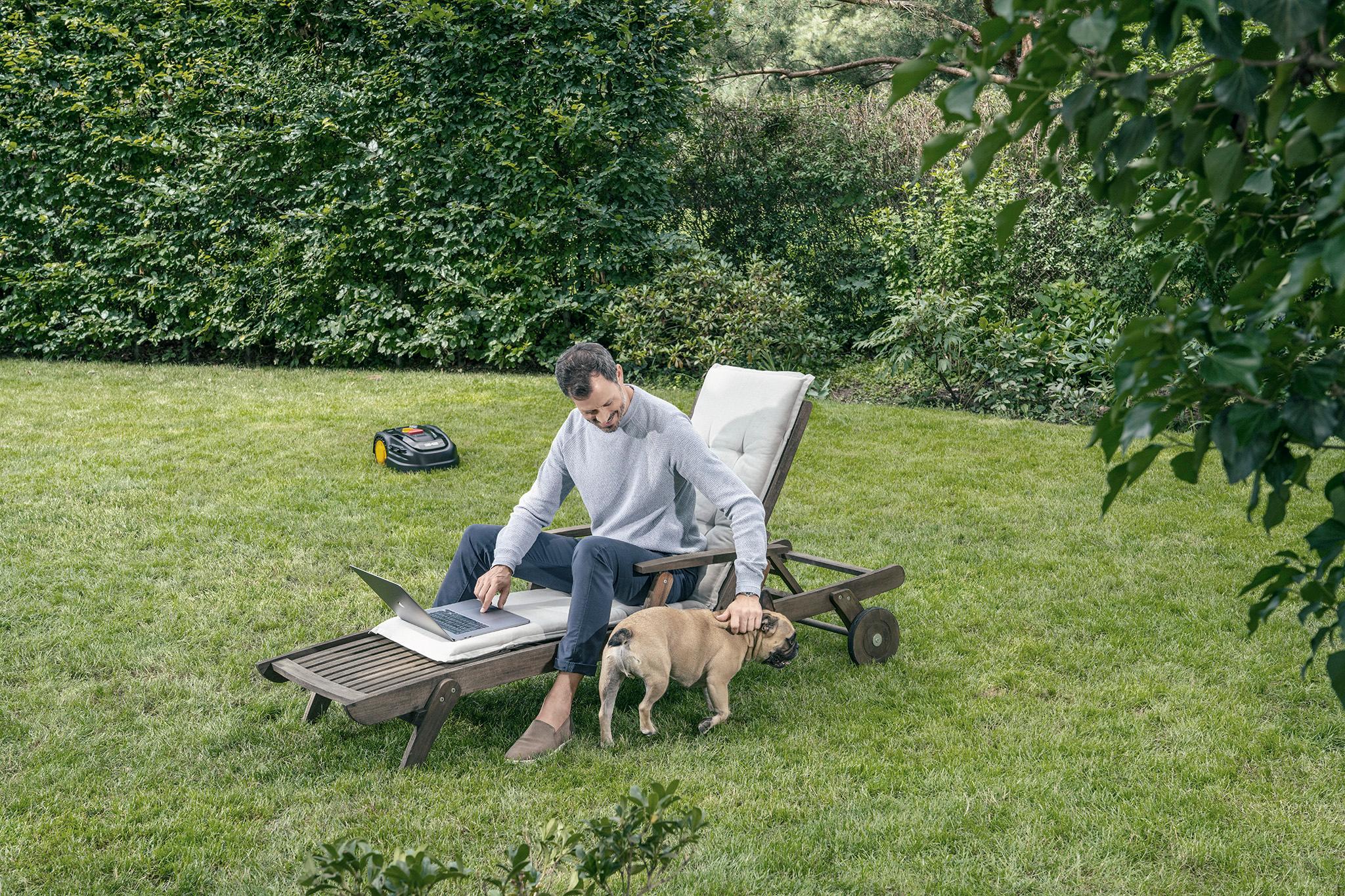 Mann mit Laptop und Hund im Garten -  Wärmegewinnung durch Sonnenenergie
