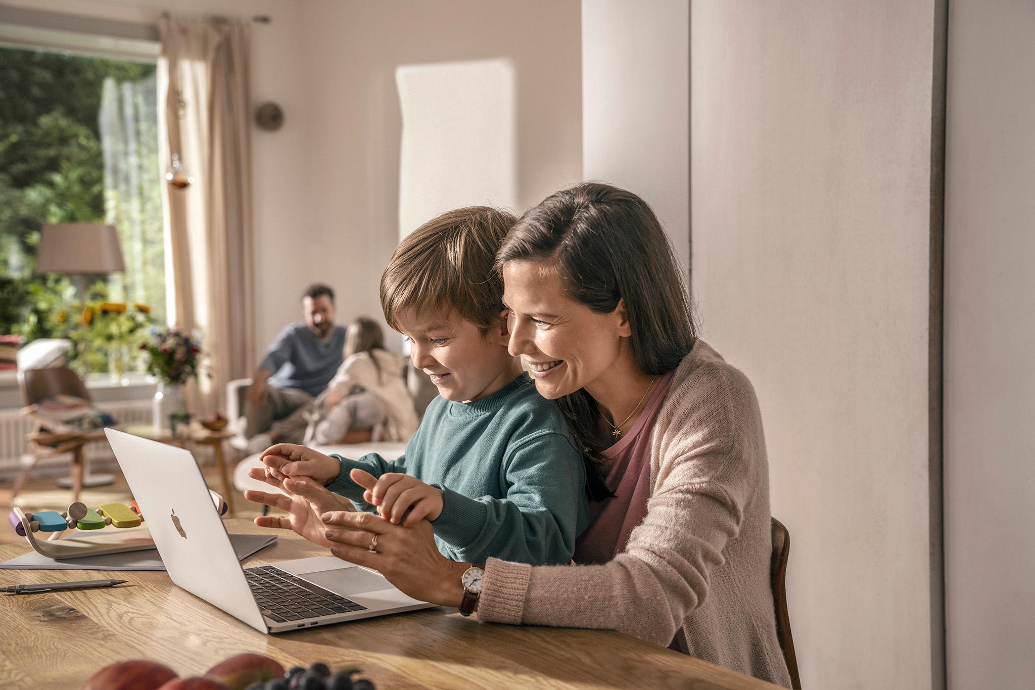 Frau und Sohn benutzen Laptop - PV-Anlage und Kleinunternehmerregelung erklärt