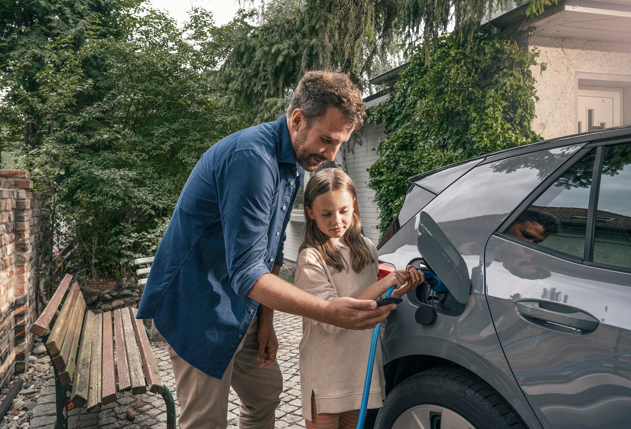 Vater zeigt Tochter wie ein E-Auto geladen wird – Sparpotenzial bei Solaranlagen